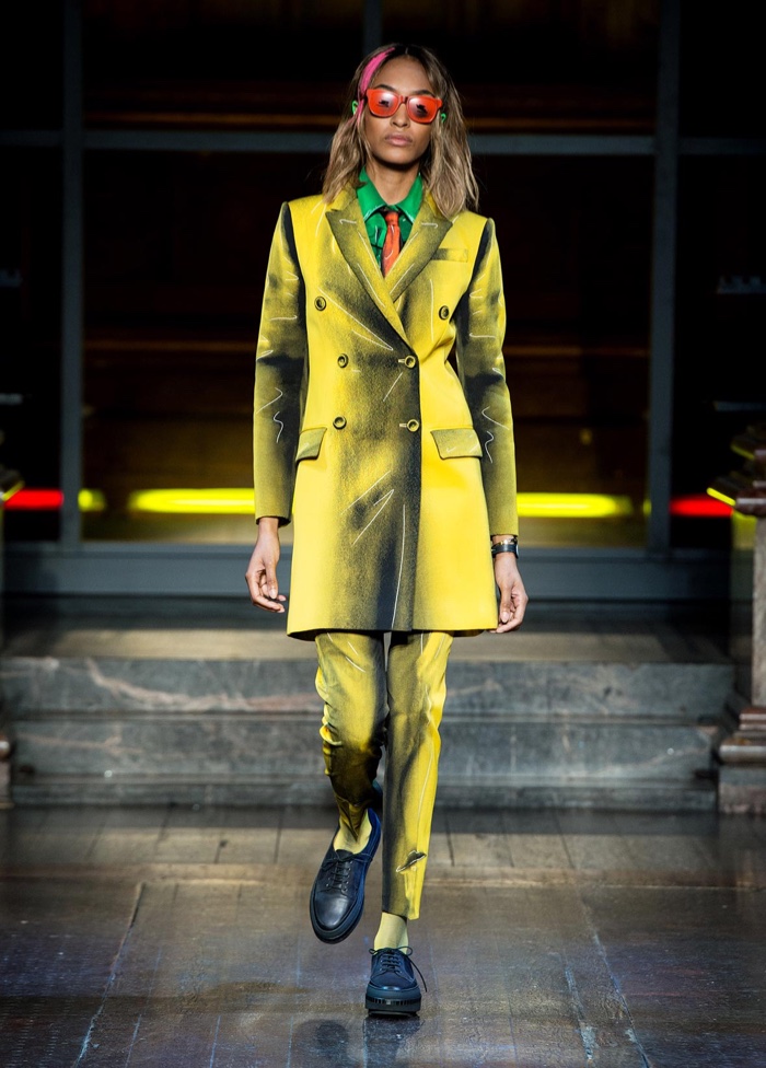 SUITING UP: Jourdan Dunn walks the runway at Moschino's fall-winter 2016 show wearing a yellow pant suit with graphic detail