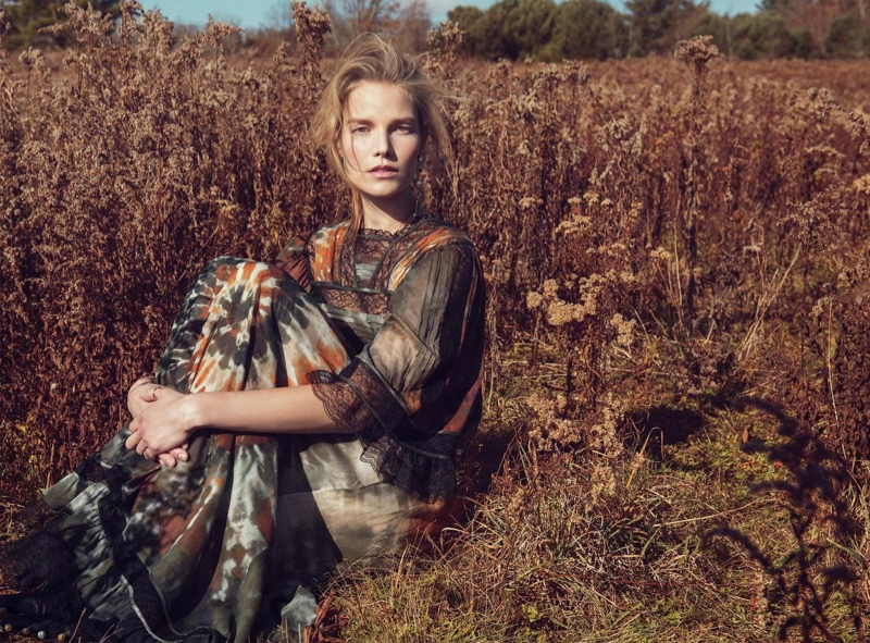Suvi poses in a field wearing abstract print dress from Valentino