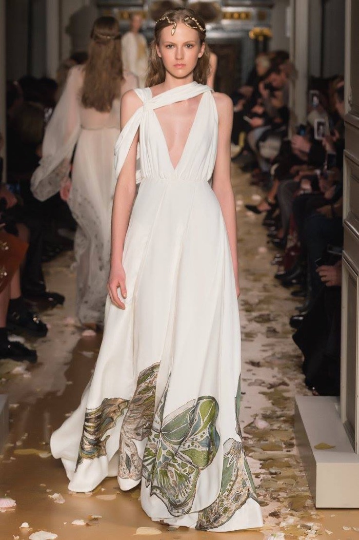 A model walks the runway at Valentino's spring 2016 haute couture show wearing a white gown with velvet embroidered butterflies