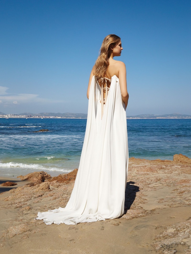 Posing seaside, Elisabeth models a wedding dress with a dramatic train addition