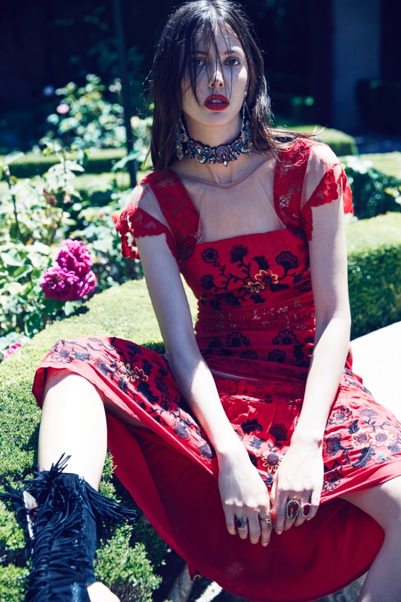 Posing outdoors, the model wears a red dress with floral embroidery from For Love & Lemons' spring 2016 collection
