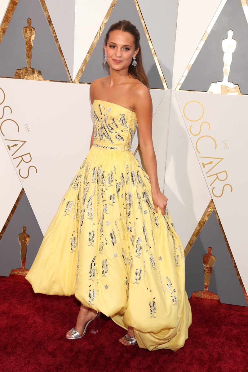 FEBRUARY 2016: Alicia Vikander attends the 2016 Oscars wearing a yellow Louis Vuitton dress with a high-low hemline. Photo: Helga Esteb / Shutterstock.com