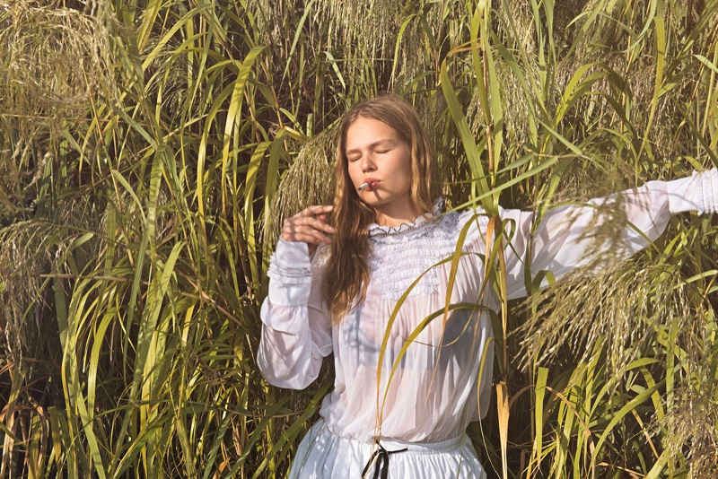 With a cigarette in hand, Anna Ewers poses in a white Louis Vuitton blouse and skirt