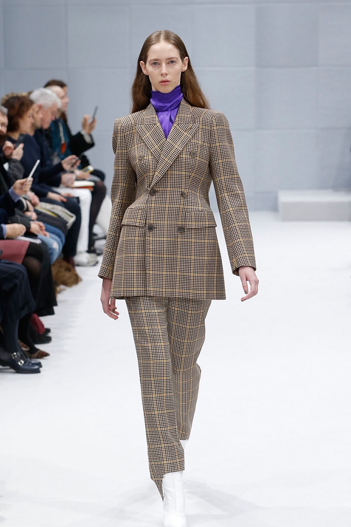 A model walks the runway at Balenciaga's fall-winter 2016 show wearing a plaid jacket and trousers