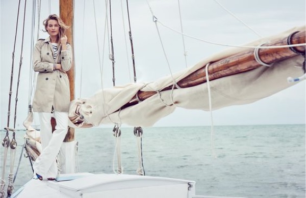 Posing on a boat, Behati Prinsloo wears a khaki coat and white pants from Tommy Hilfiger