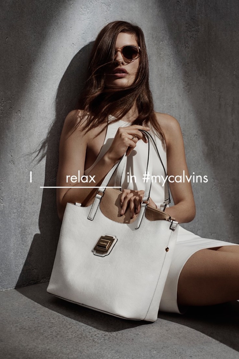 Posing with sunglasses and an oversized tote, Julia models a white mini dress from Calvin Klein White Label's spring 2016 collection