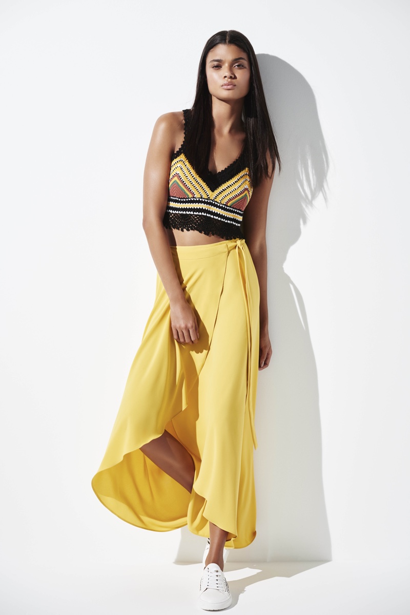 Daniela Braga models a knitted crop top with a yellow maxi skirt