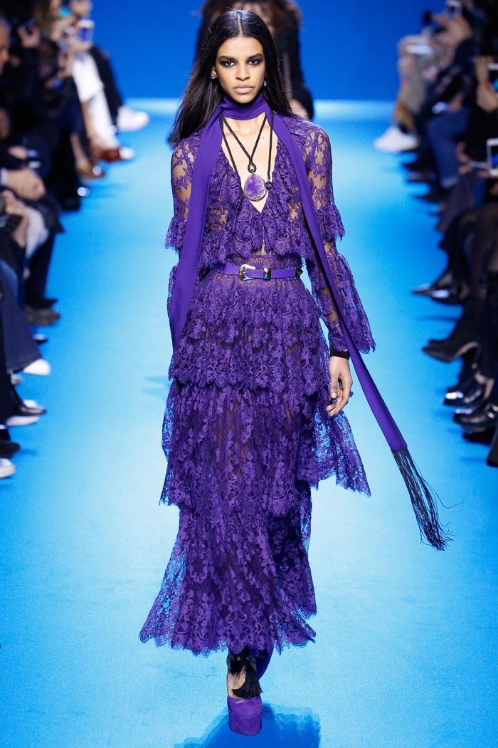 A model walks the runway at Elie Saab's fall-winter 2016 show wearing a purple lace gown with tiers