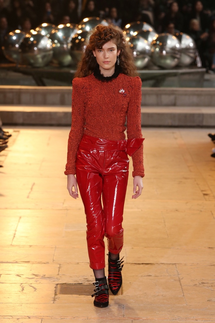 A model walks the runway at Isabel Marant's fall-winter 2016 show wearing a red sweater and patent leather pants