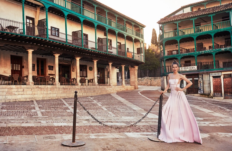 Posing on cobbled streets, Jessica Miller models a pink dress designed by Carolina Herrera