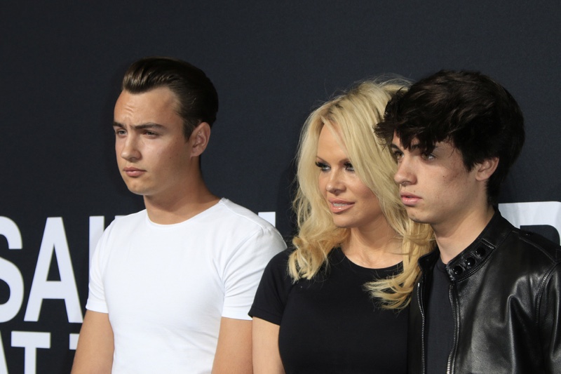 FEBRUARY 2016: Pamela Anderson attends Saint Laurent's fall 2016 show with sons Brandon and Dylan Lee. Photo: Joe Seer / Shutterstock.com