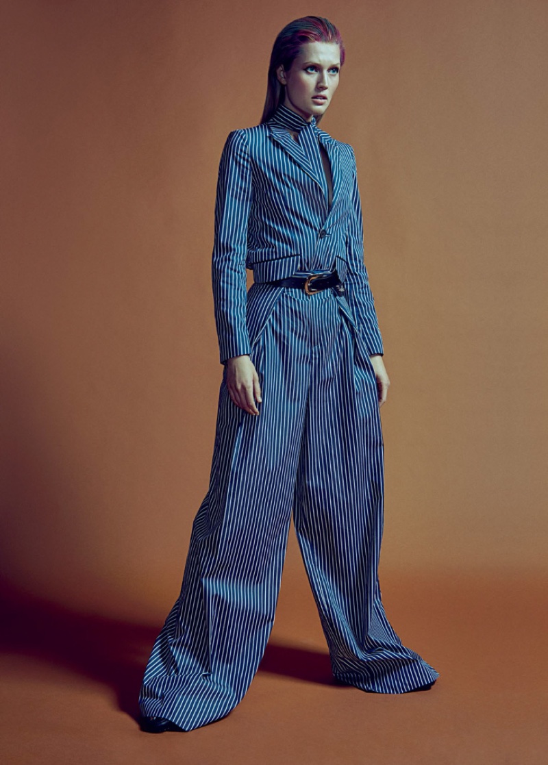 Channeling menswear style, Toni Garrn poses in wide-fit trousers with a slicked back hairstyle