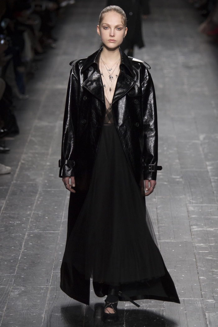 A model walks the runway at Valentino's fall-winter 2016 show wearing a black maxi dress and leather jacket