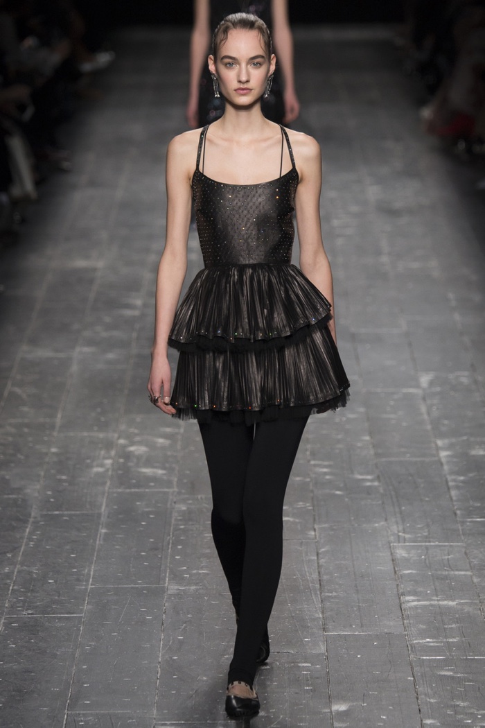 A model walks the runway at Valentino's fall-winter 2016 show wearing black dress with tiered ruffles