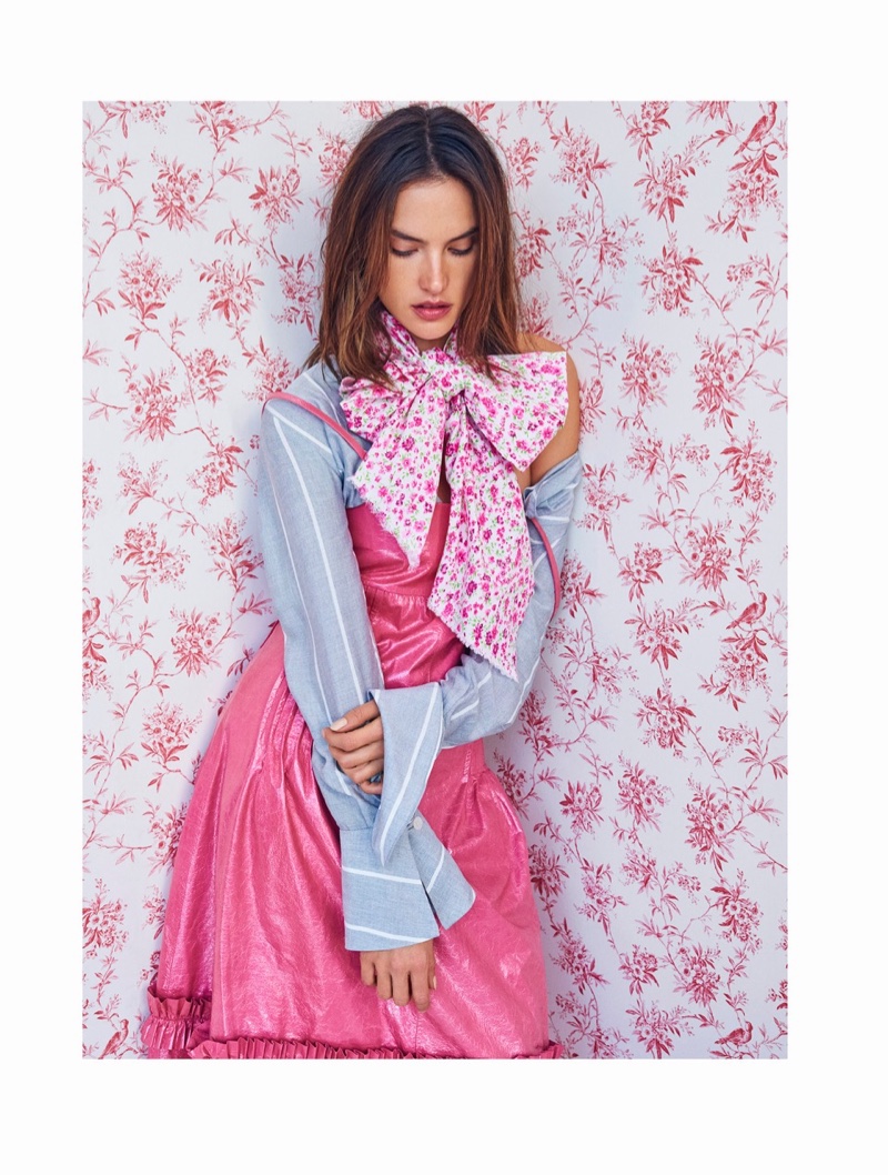 Posing against a floral backdrop, Alessandra Ambrosio wears a bow, fruffled sleeves and pink dress