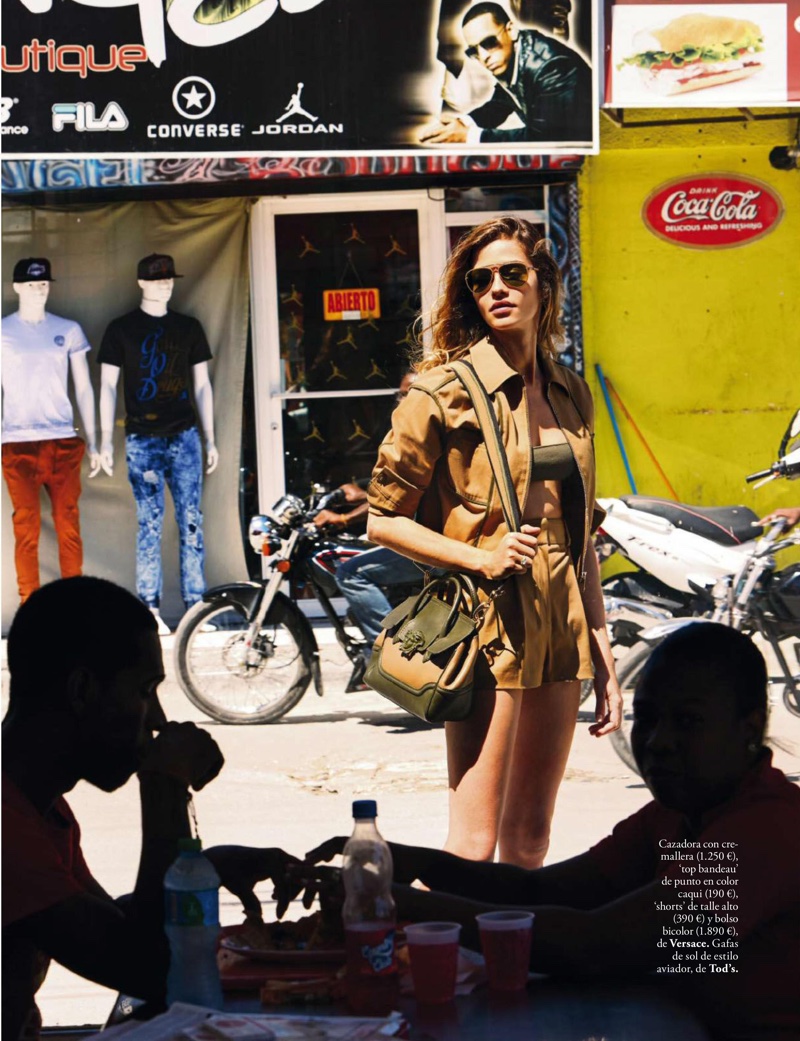 Embracing neutral hues, Ana models a jacket, bandeau top, shorts and bag from Versace