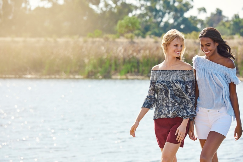 The models pose in the sunny outdoors wearing summer fashions