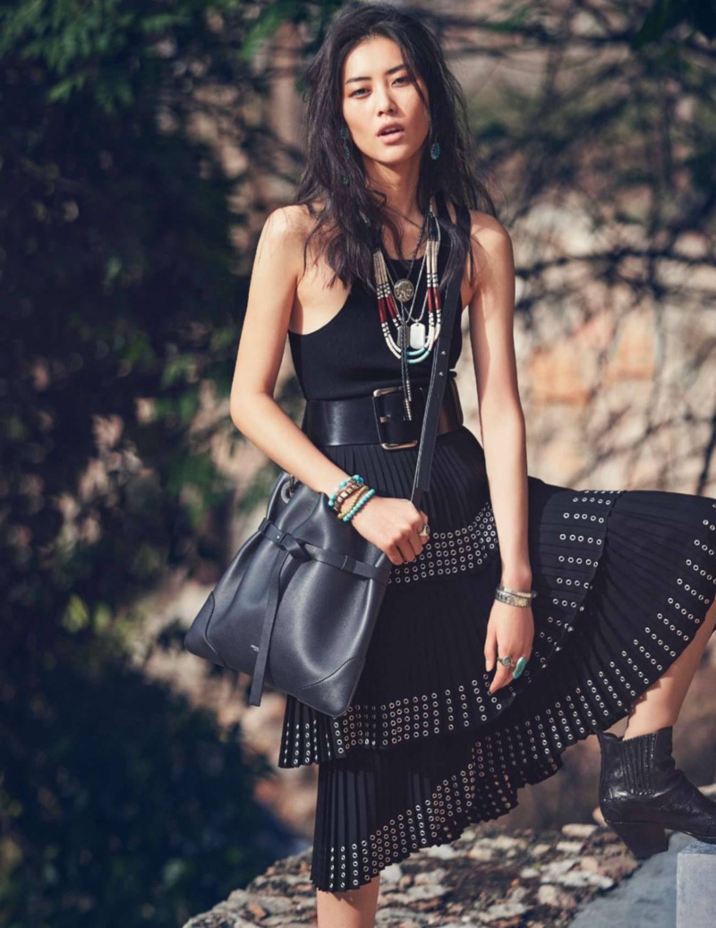 Clad in black, Liu Wen models a Michael Kors Collection tank top and pleated skirt with grommet embellishments