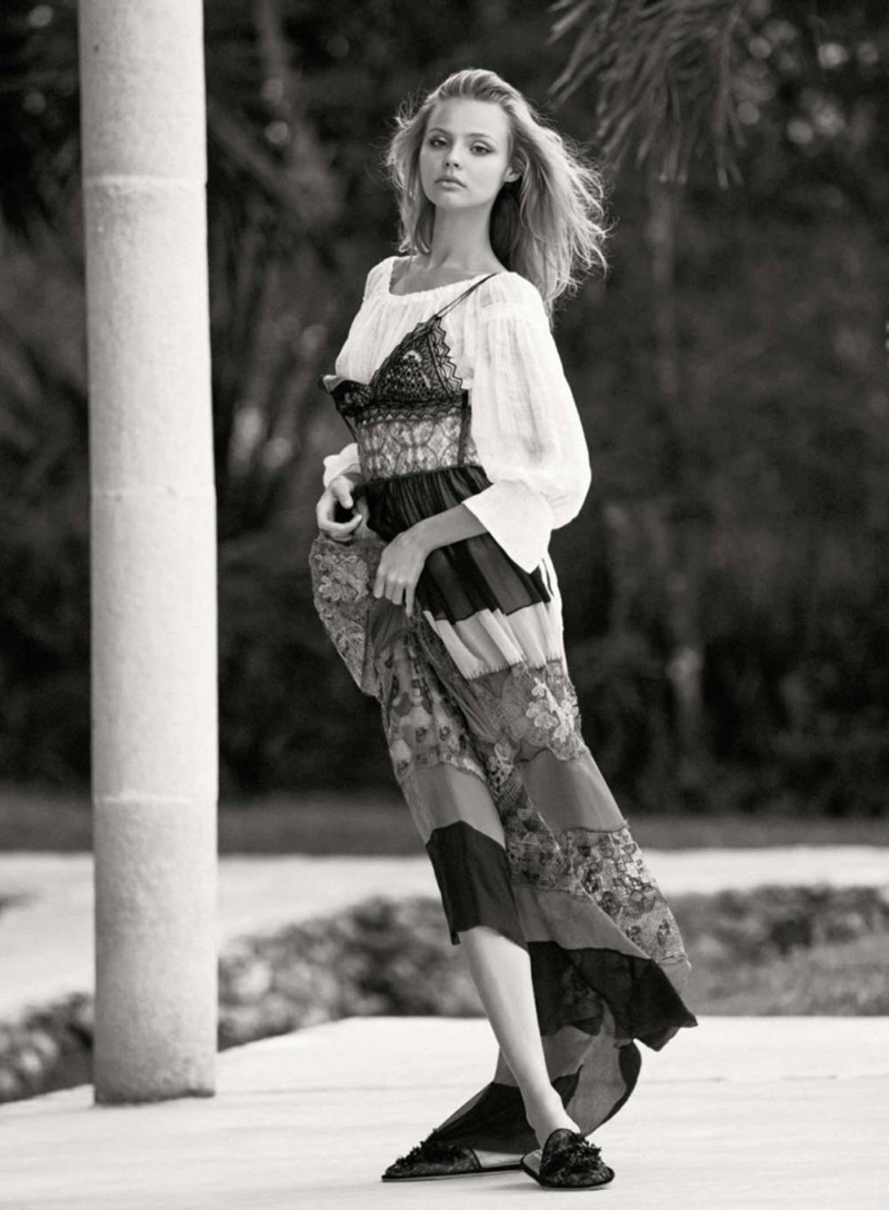 Photographed in black and white, Magdalena wears a white blouse and maxi dress from Alberta Ferretti