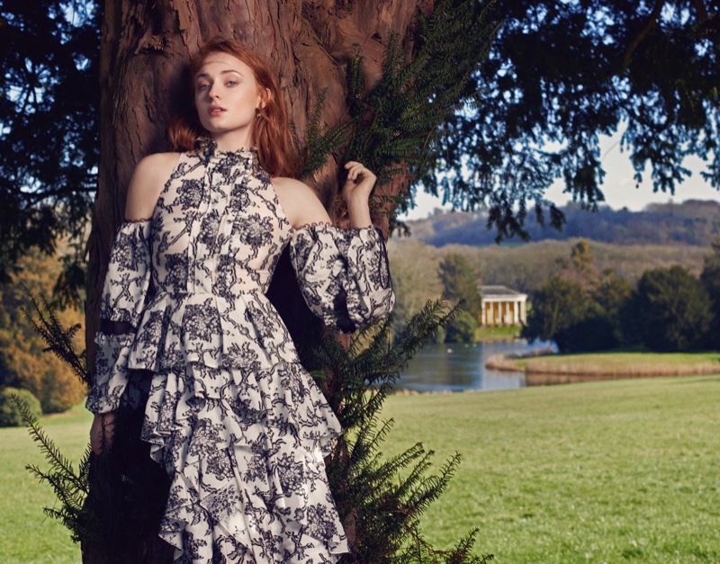 Sophie Turner poses in an Erdem top with open shoulder and matching skirt featuring ruffles