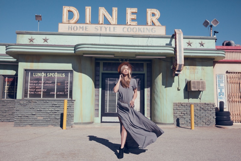 Posing outside a diner, model wears grey maxi dress from Wildfox