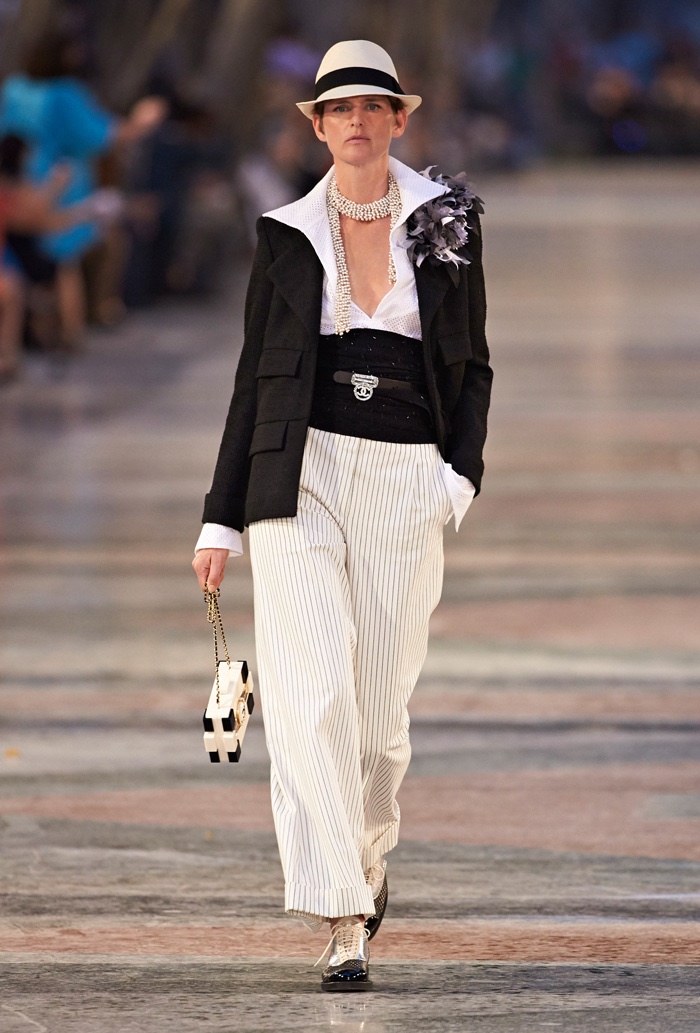 Stella Tennant walks Chanel’s cruise 2017 show wearing a Panama hat, long jacket, belted shirt and wide-leg trousers