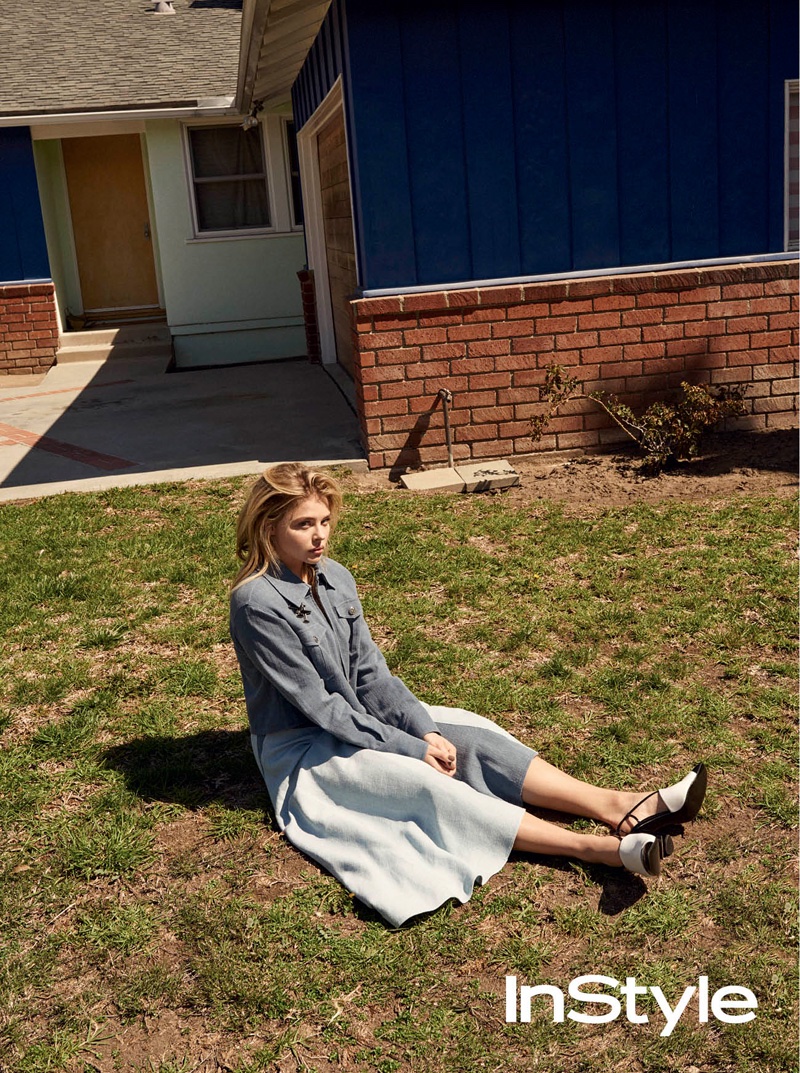 Posing on grass, Chloe Grace Moretz wears blue jacket and skirt look