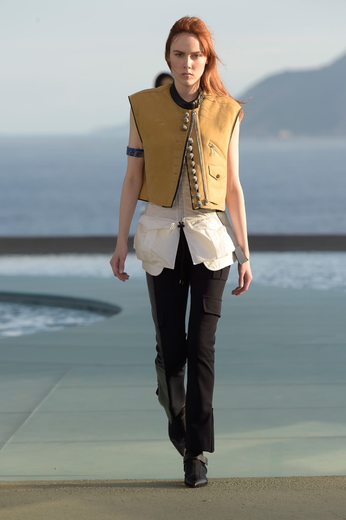 A model walks the runway at Louis Vuitton’s resort 2017 show wearing a cropped vest, long blouse and fitted trousers