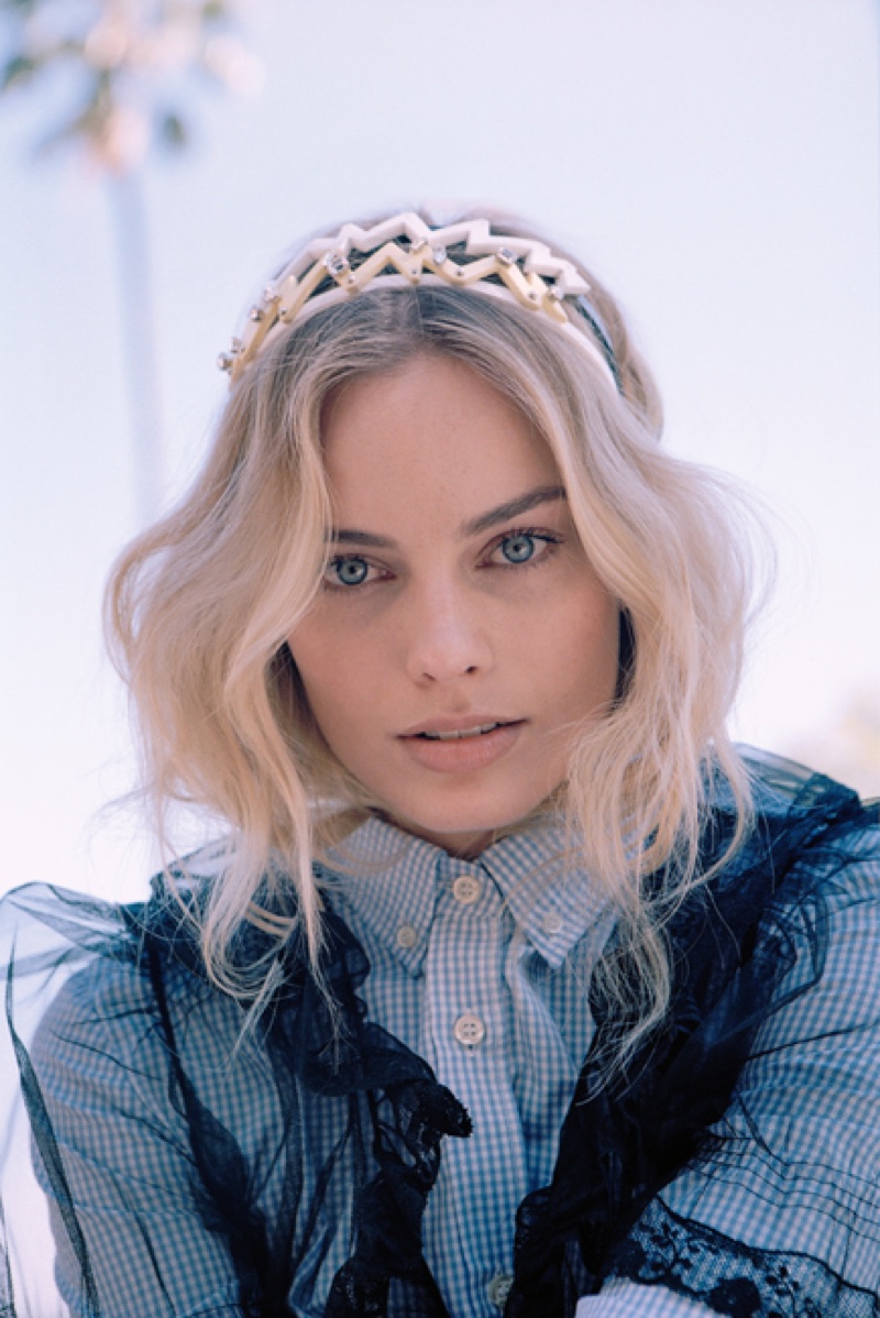 With her blonde hair in carefree waves, Margot Robbie wears Miu Miu shirt, dress and embellished headbands