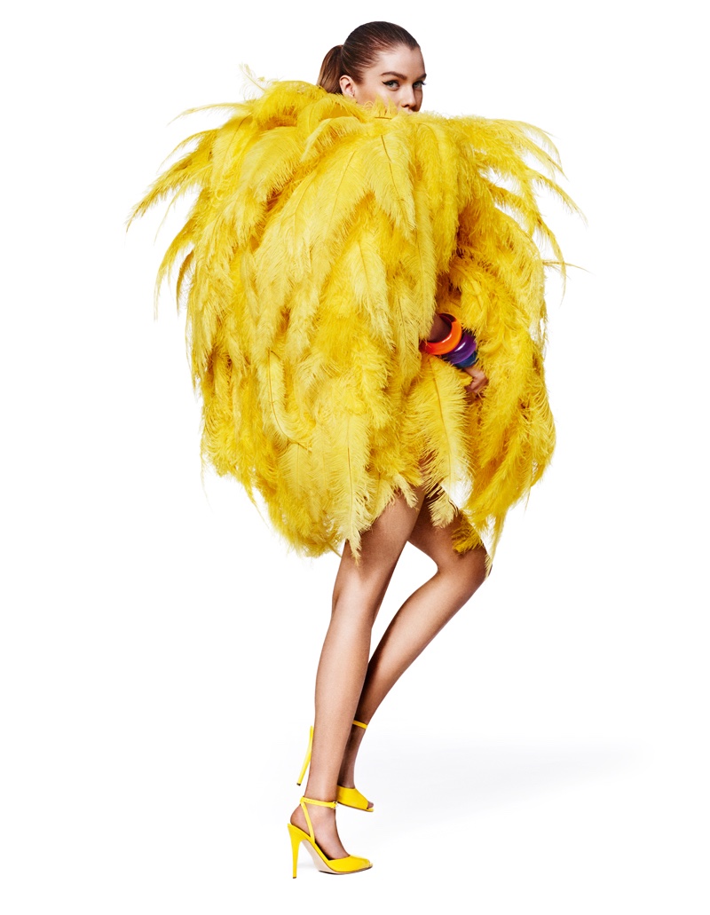 The blonde poses in Moschino dress with yellow feathers