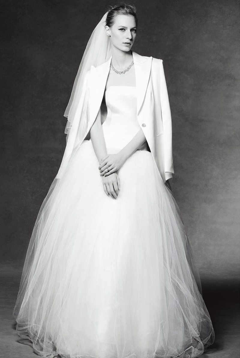 Having a bridal moment, Julia Nobis poses in a white wedding gown with a jacket and veil. All jewelry by Tiffany & Co.