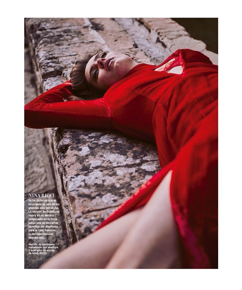 The model poses in red dress from Nina Ricci