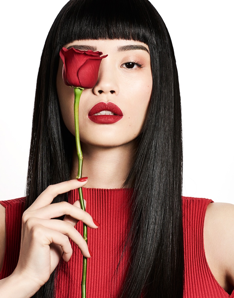 Posing with a rose, Ming Xi wears dark red lipstick shade