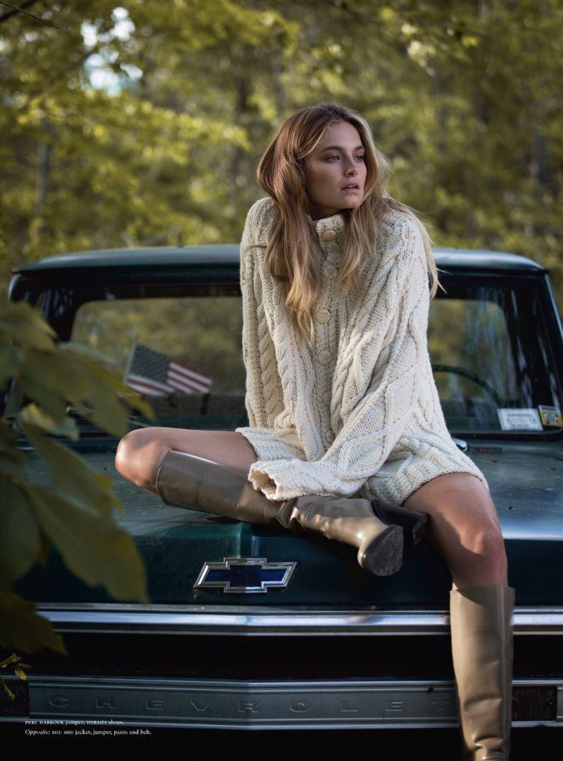 Bridget Malcolm poses on the back of a pickup truck in Purl Harbour sweater and Hermes boots