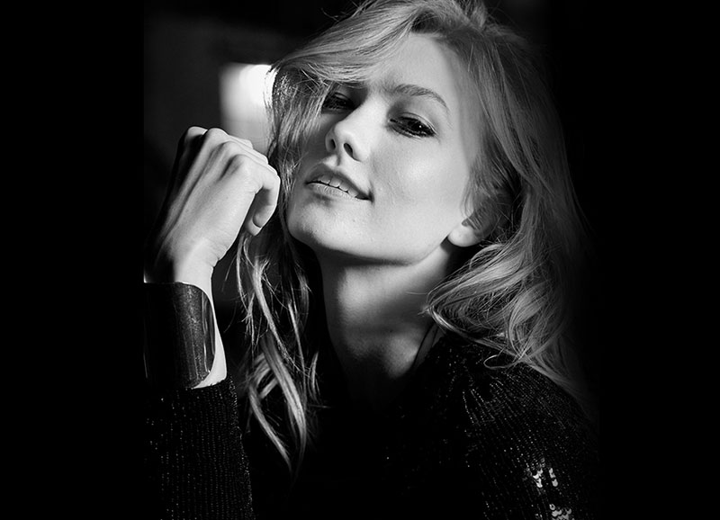 Photographed in black and white, Karlie Kloss gives a coy look on set of Carolina Herrera fragrance shoot