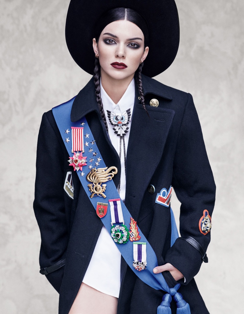 Model Kendall Jenner poses in wide-brimmed hat with embroidered sash and blazer