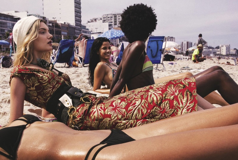 Alongside beachgoers, Lily poses in Prada hat, dress and belt