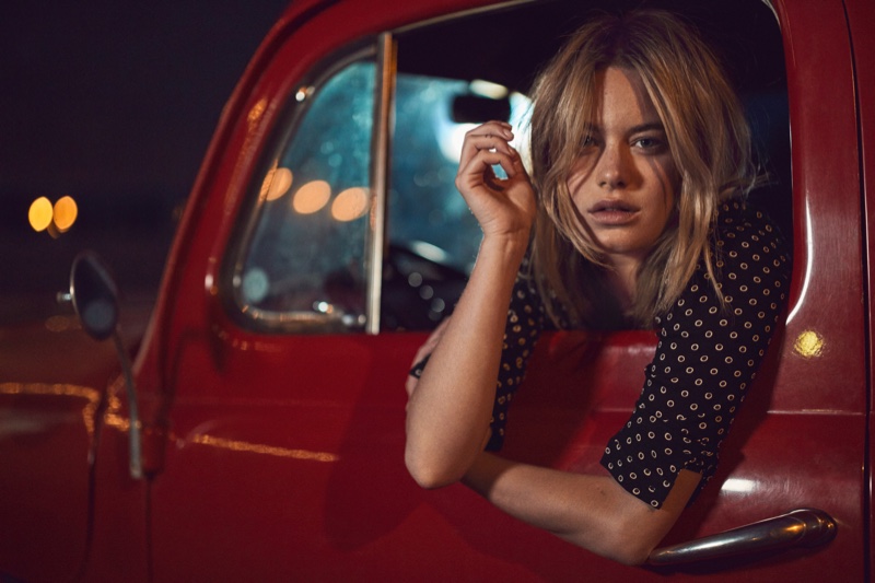 Posing in a pickup truck, Camille Rowe models bow neck shirt