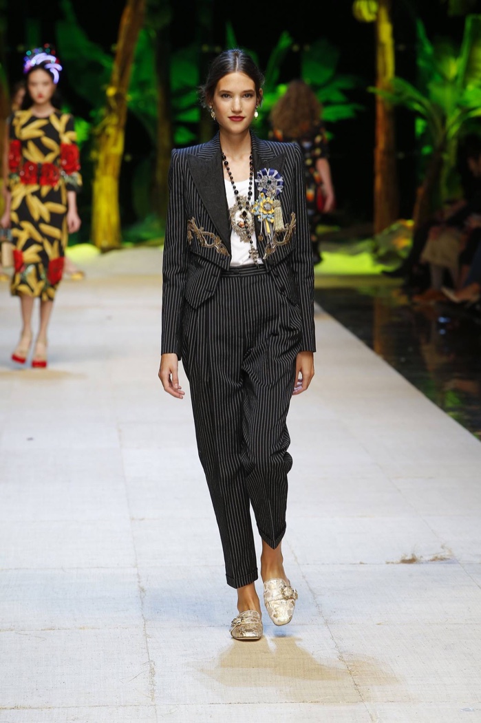 Dolce & Gabbana Spring 2017: Model walks the runway in pinstriped jacket and pants with brooches and gold embroidery 
