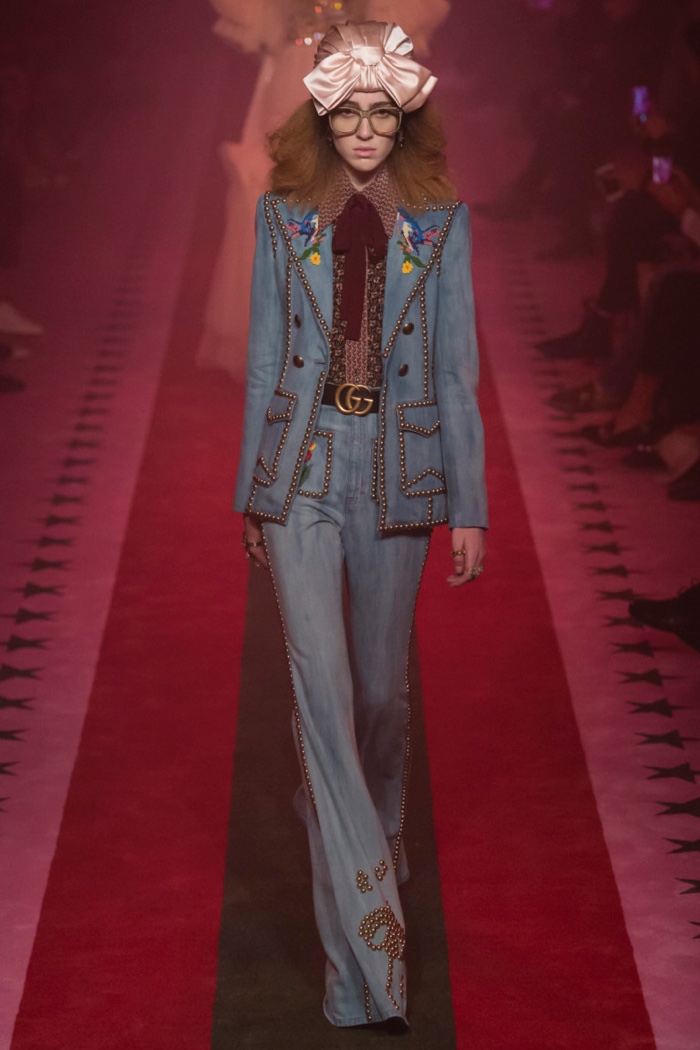 Gucci Spring 2017: Model walks the runway in denim pantsuit with stud embellishments and printed blouse
