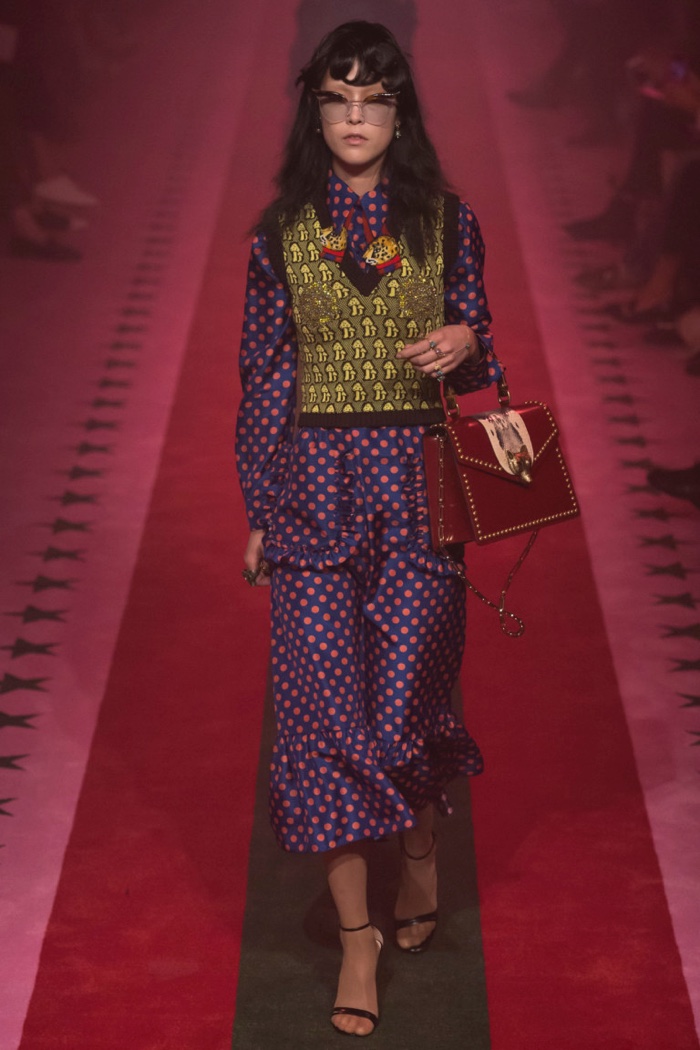Gucci Spring 2017: Model walks the runway in sweater vest over polka dot print dress