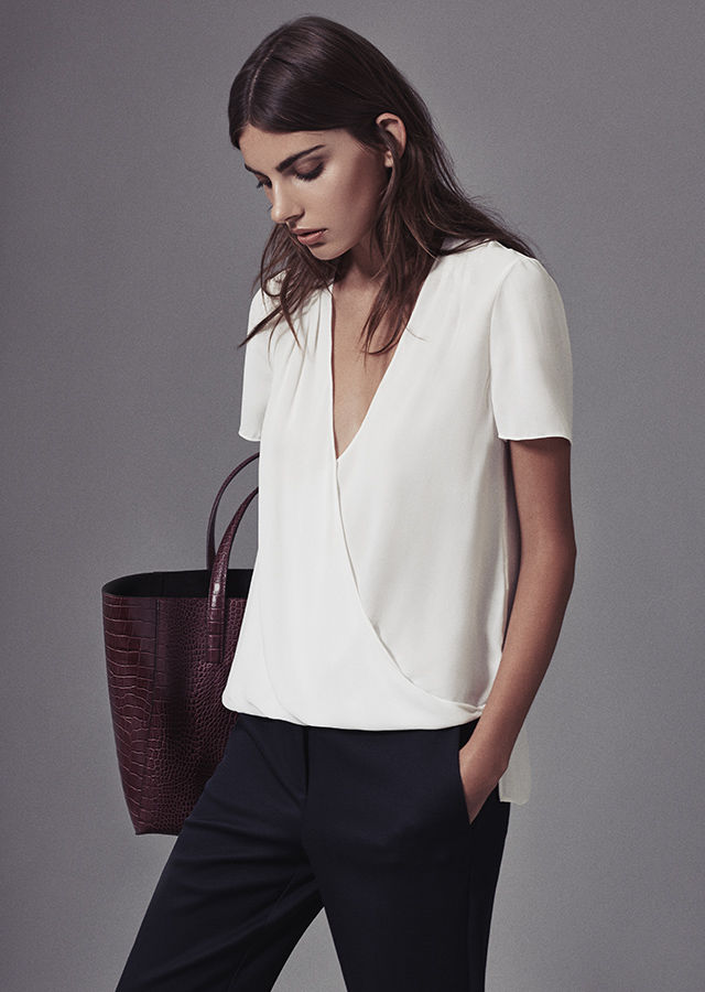 Reiss Bella Plisse-Detail Wrap Off-White Top, Joanne Cropped Tailored Trousers, and Louie Open-Top Burgundy Tote.