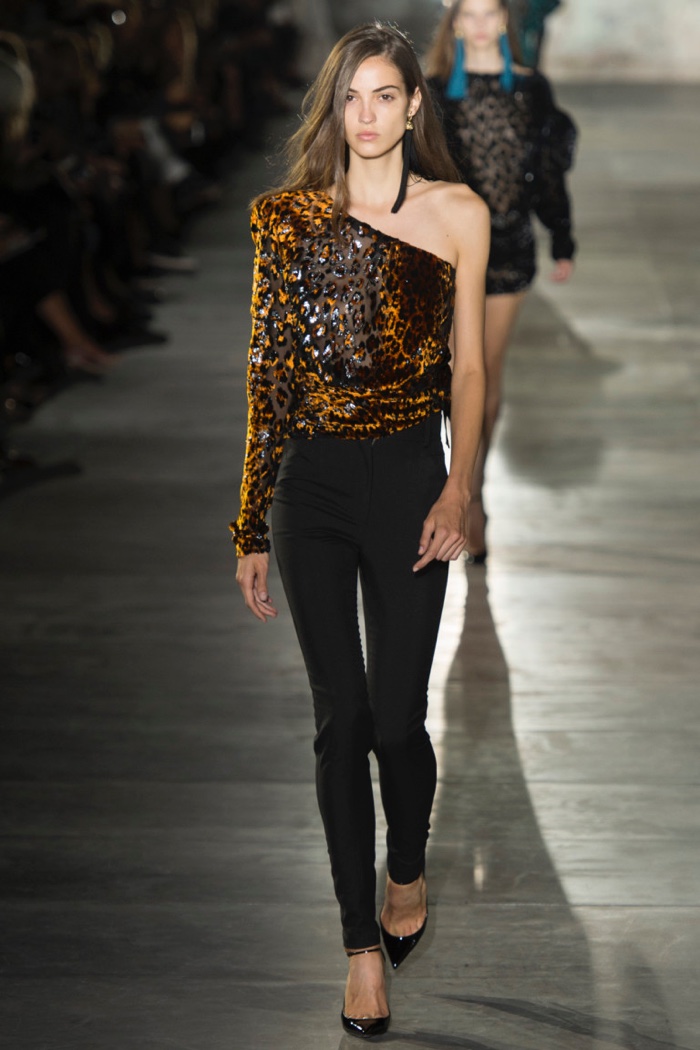 Saint Laurent Spring 2017: Camille Hurel walks the runway in one-shoulder blouse with animal print motif over high-waist skinny pants