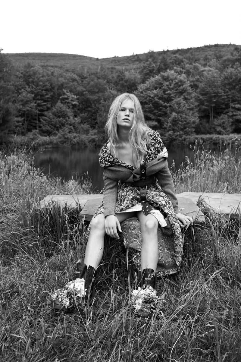 Posing outdoors, Anna Ewers models a cardigan and floral skirt from Miu Miu