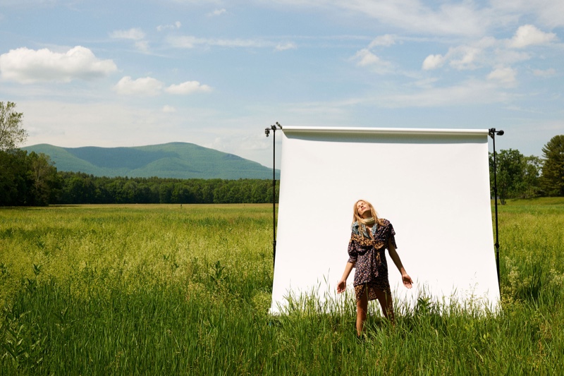 With arms outstretched, Anna Ewers poses in a field of grass for the editorial