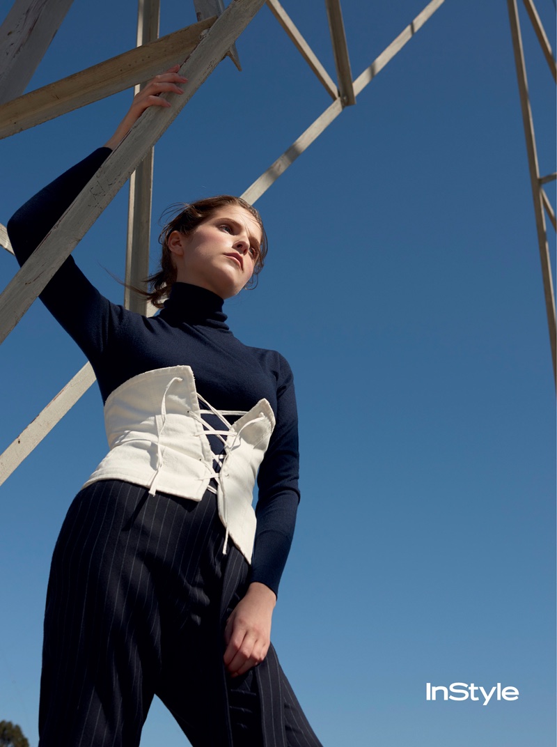 Anna Kendrick poses in turtleneck with corset and pinstriped pants