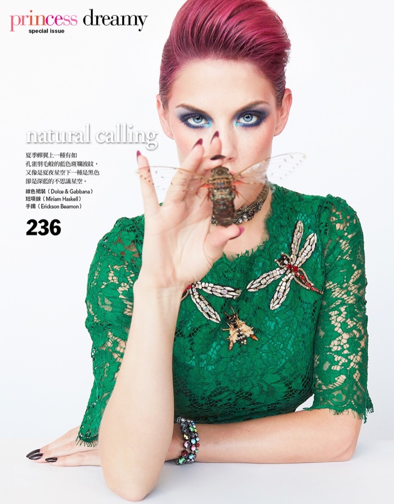 Wearing a green lace dress from Dolce & Gabbana, Ashley Smith poses with insect brooches