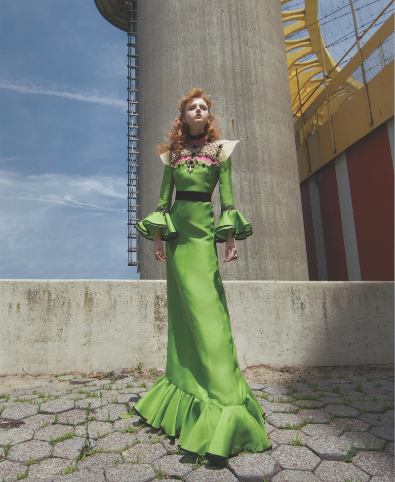 The model wears a green Gucci dress with flared sleeves and hemline