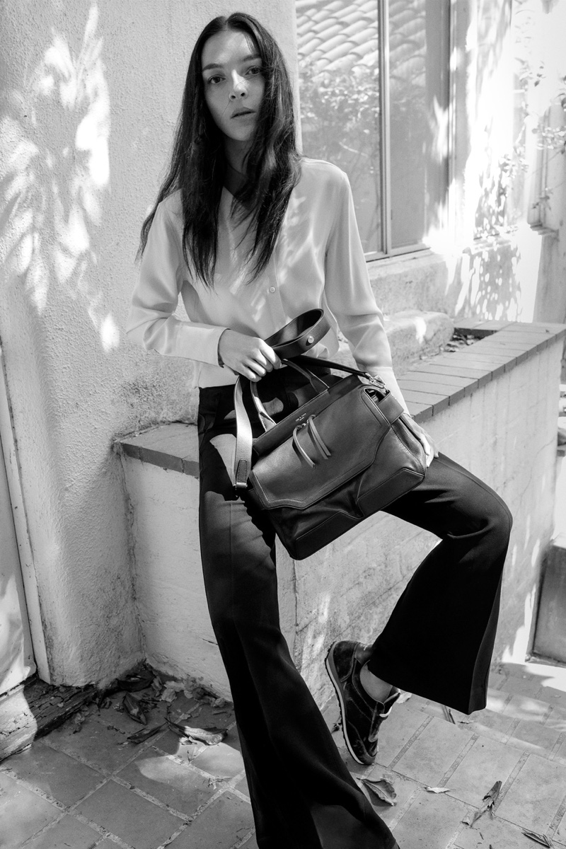 Photographed in black and white, Mariacarla Boscono models rag & bone Hayden Rib Shirt in Bright White, Abel Pant in Black, Pilot Satchel in Black and Dylan Runner in Navy Velvet