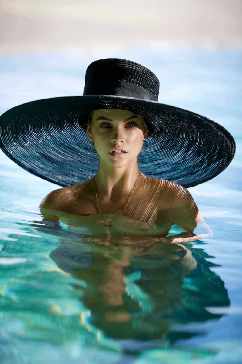 Posing in a pool, Barbara Palvin wears a wide-brimmed sun hat